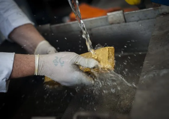 A finished gold bar being rinsed clean at the Sharjah refinery